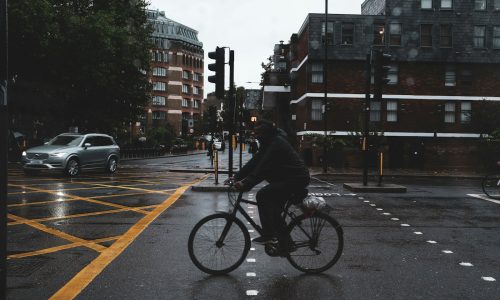 a man riding a bike down a rain soaked street
